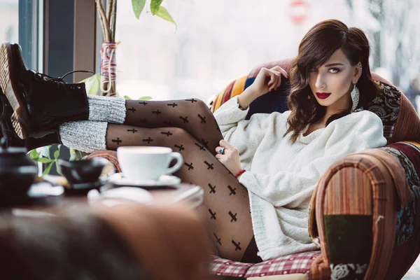 Chica joven bebiendo café en un café de moda — Foto de Stock