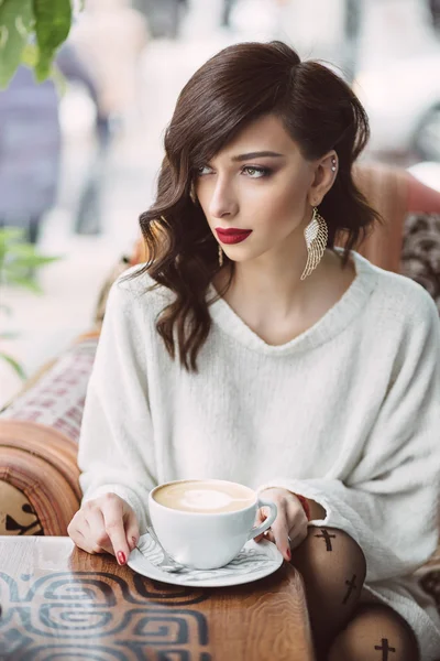Jovem bebendo café em um café na moda — Fotografia de Stock