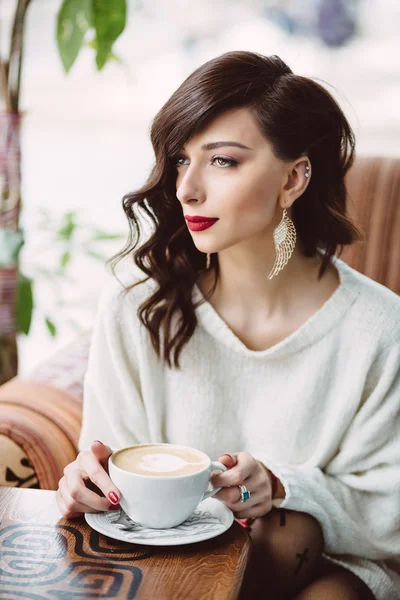 Młoda dziewczyna picia kawy w modnych kawiarni — Zdjęcie stockowe