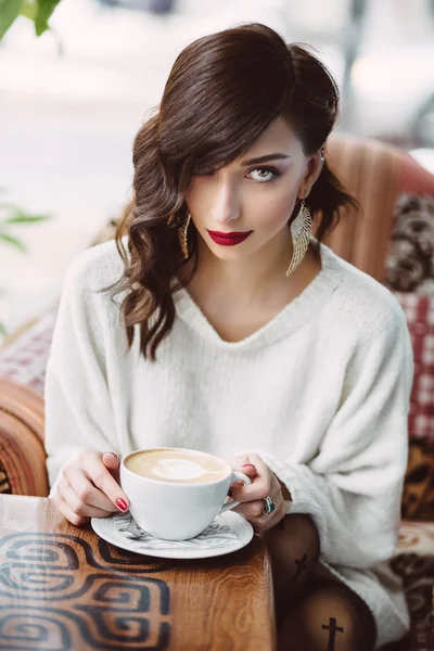 Chica joven bebiendo café en un café de moda — Foto de Stock