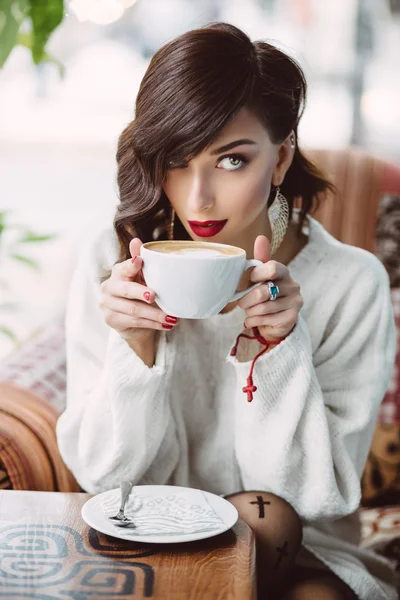 Chica joven bebiendo café en un café de moda — Foto de Stock