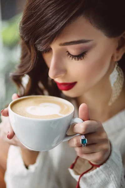 Chica joven bebiendo café en un café de moda — Foto de Stock