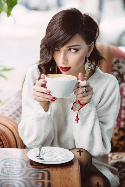 Chica joven bebiendo café en un café de moda — Foto de Stock