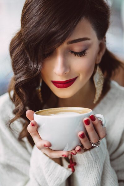 Young girl drinking coffee in a trendy cafe