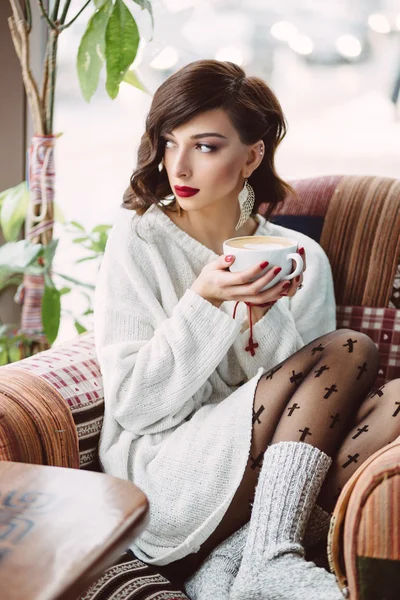 Young girl drinking coffee in a trendy cafe — Stock Photo, Image