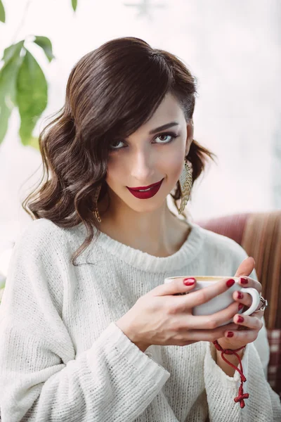 Fiatal lány a divatos kávézójában kávét iszik — Stock Fotó