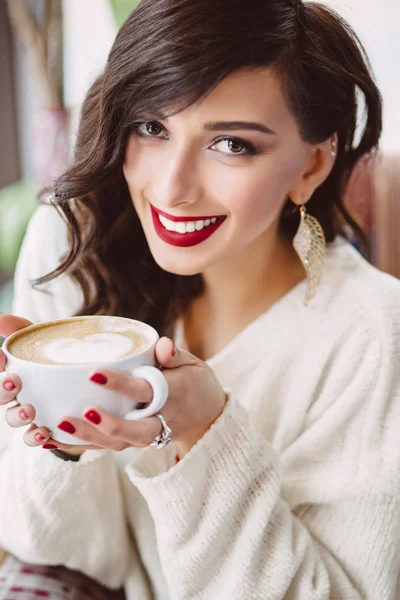 Young girl drinking coffee in a trendy cafe — Stock Photo, Image