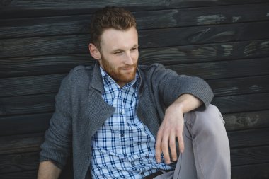 ahşap yerde otururken yakışıklı genç