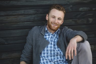 ahşap yerde otururken yakışıklı genç