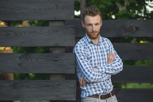 Porträt eines jungen modischen Mannes gegen Holzzaun — Stockfoto