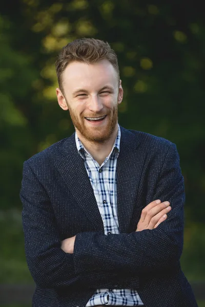 Schöner junger Mann lächelt draußen — Stockfoto