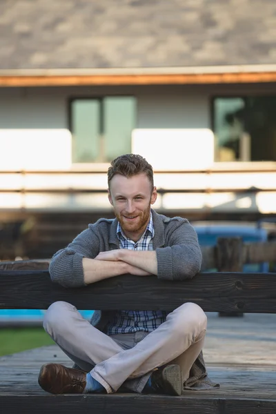 Portret van knappe jonge man die lacht buitenshuis — Stockfoto