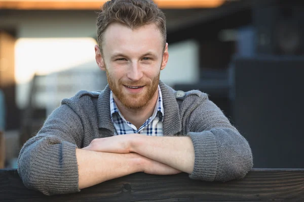 Portret van knappe jonge man die lacht buitenshuis — Stockfoto