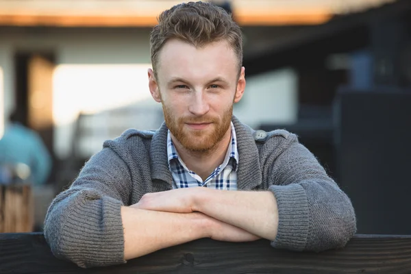 Portret van knappe jonge man die lacht buitenshuis — Stockfoto