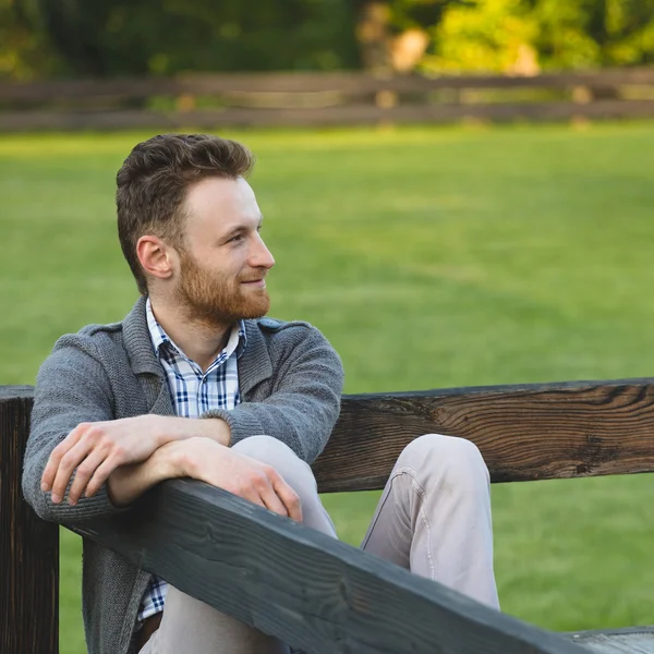 Portret van knappe jonge man die lacht buitenshuis — Stockfoto