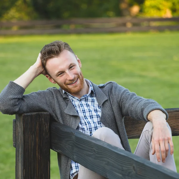 Portret van knappe jonge man die lacht buitenshuis — Stockfoto