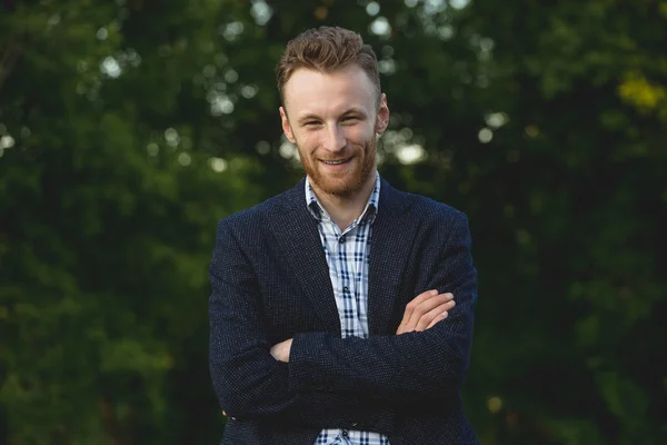 Schöner junger Mann lächelt draußen — Stockfoto