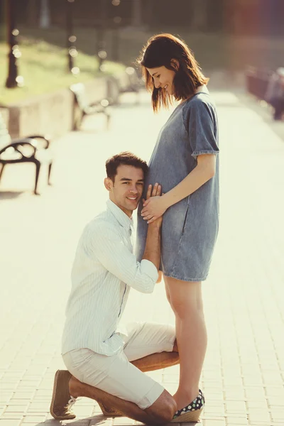 Glückliche und junge schwangere Paare, die sich in der Natur umarmen. Vintage-Retro — Stockfoto
