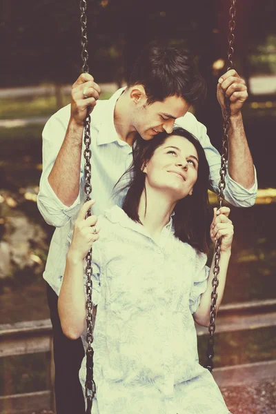 Feliz y joven pareja embarazada abrazándose en la naturaleza. Vintage retro — Foto de Stock