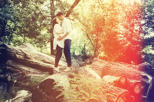 Glückliche und junge schwangere Paare, die sich in der Natur umarmen. Vintage-Retro — Stockfoto