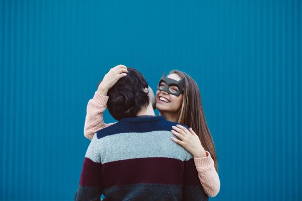 Mädchen in einer Maske küsst ihren jungen Mann. — Stockfoto