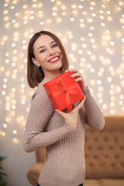 Portre genç güzel bir kadın bir hediye kutusu tutuyor.