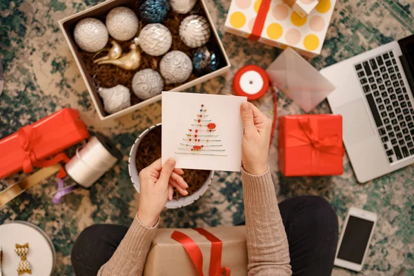 Adorável jovem mãos segurando um cartão de saudação de Natal — Fotografia de Stock