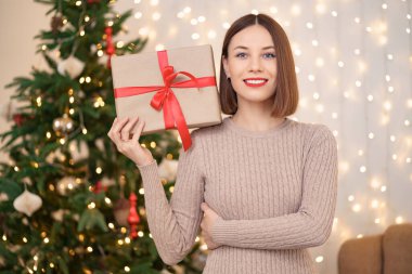 Portre genç güzel bir kadın bir hediye kutusu tutuyor.