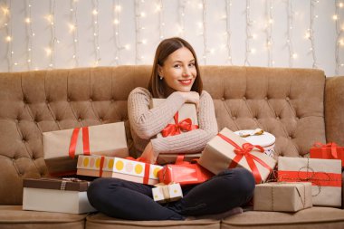 Güzel esmer kadın hediye kutularına sarılıyor.