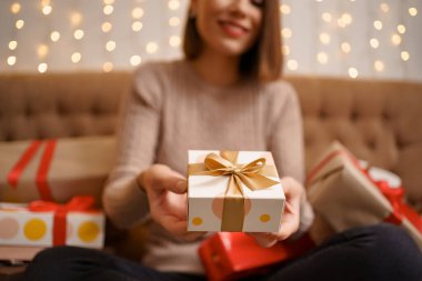 Güzel esmer kadın elinde güzel bir hediye kutusu tutuyor.