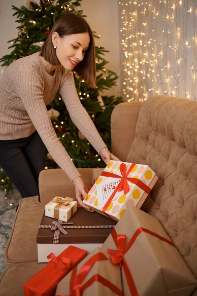 Femme touchant cadeaux de Noël cadeaux à la maison — Photo
