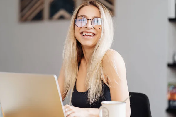 Mladá žena nosí brýle sedět za stolem sledovat webinář dělat poznámky — Stock fotografie
