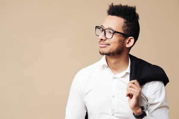 Afro bom cara olhando no branco camisa e óculos posando no bege fundo — Fotografia de Stock