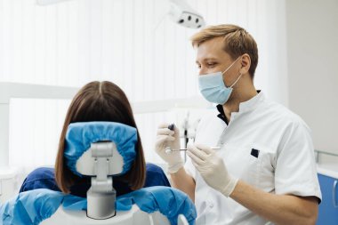 Dişçi, klinikteki aletleri kullanarak hasta boşluğunu kontrol ediyor.