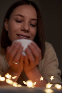 Parlayan ışıklarla yatakta uzanmış güzel bir kadın