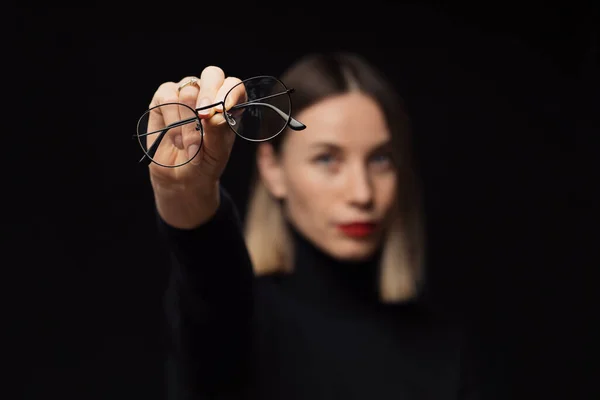 Vrouw tonen brillen naar camera op zwarte achtergrond — Stockfoto