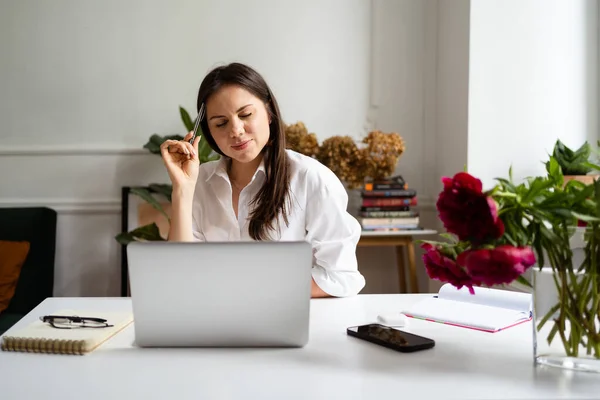 Imprenditrice che lavora sul computer portatile seduta a casa e gestisce la sua attività tramite home office — Foto Stock