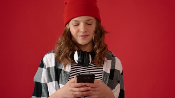 Girl teenager using smartphone on red background — Stok video