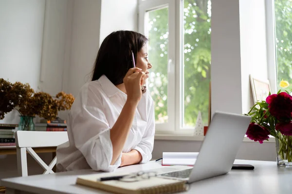 Empresária trabalhando no computador portátil sentado em casa e gerenciando seu negócio via home office — Fotografia de Stock