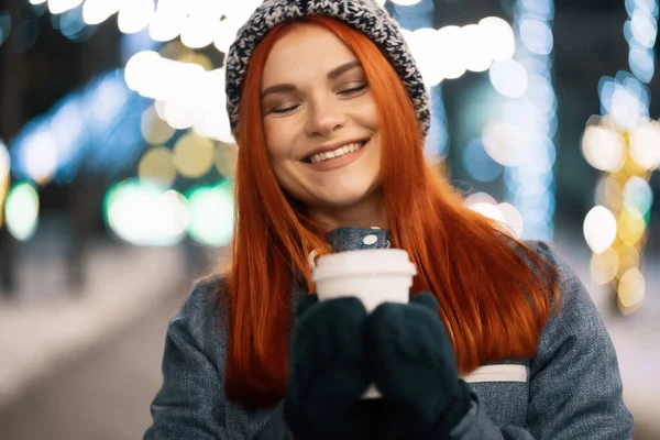 Sorrindo jovem mulher desfrutando de uma xícara de café ao ar livre — Fotografia de Stock