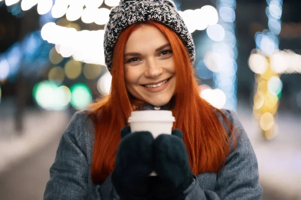 Sorrindo jovem mulher desfrutando de uma xícara de café ao ar livre — Fotografia de Stock