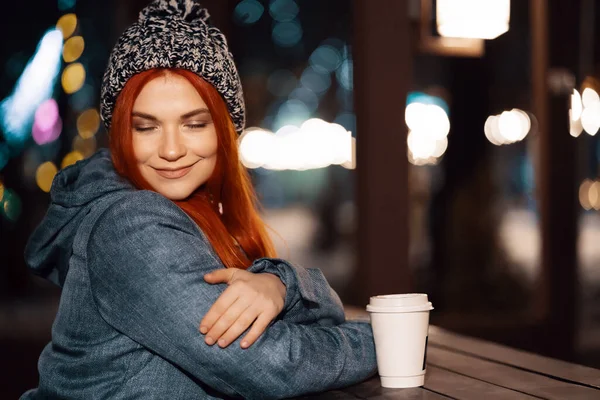 屋外のコーヒーのカップを楽しんでいる若い女性の笑みを浮かべてください。 — ストック写真