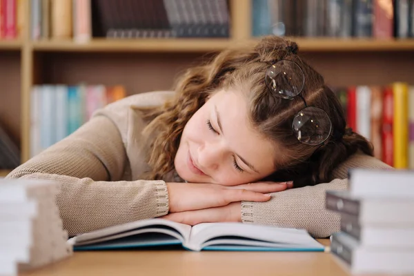 Tired student got asleep on the desk while studying among books —  Fotos de Stock