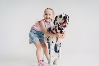 Neşeli kız köpekle oynuyor.