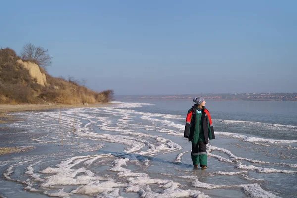 Настоящая женщина наслаждается зимней прогулкой на замерзшем озере — стоковое фото