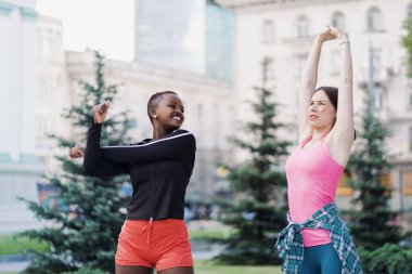 Koşu ve spor aktivitelerinden sonra şehir meydanında uzanan iki güzel kadın.