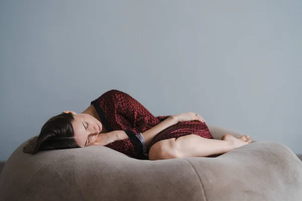 Kvinna sover sött hemma vit vägg i bakgrunden — Stockfoto