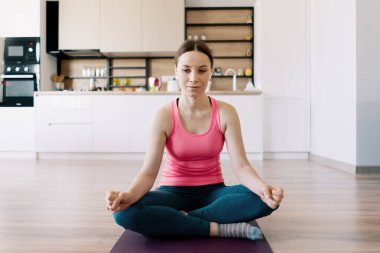 Beyaz kadın evde yoga yapıyor.
