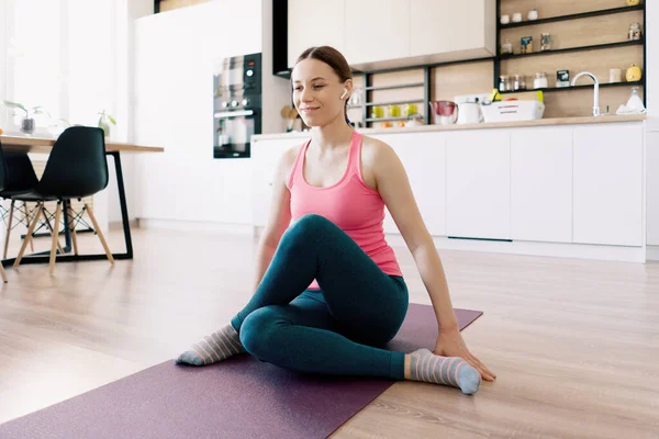 Beyaz kadın evde yoga yapıyor.