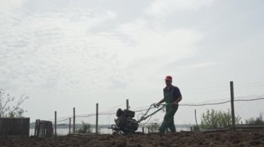 Gökyüzü arka planında tarlayı süren adam